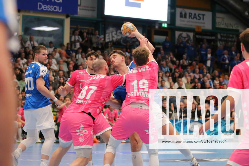 Men s Handball 2026–2027, 2nd Division, Matchday 9: Dessau Roßlauer HV 06 vs. SC DHfK Leipzig at Anhalt Arena, Dessau. Marcel Nowak (Dessau, 15, in blue) takes a shot on goal; Moritz Preuss (Leipzig, 67, in pink, and Finn Schroven, Leipzig, 19, in pink, try to block the shot Dessau-Roßlau, Saxony-Anhalt, Germany