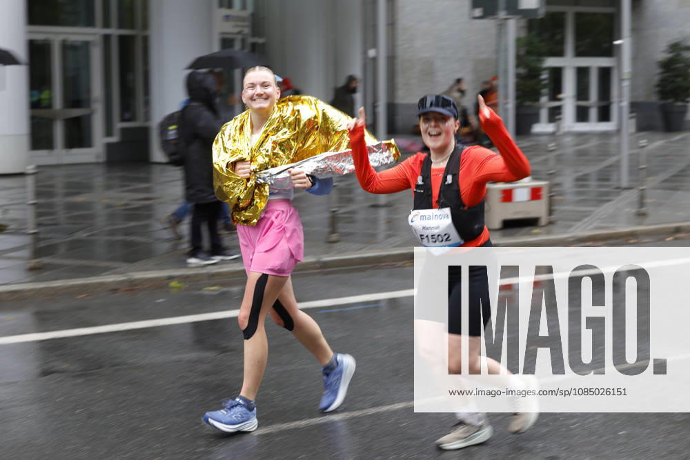 Track and Field 43 Mainova Frankfurt Marathon: Here, two female runners are enjoying the race despite the wind and rain Frankfurt, Main, Hesse, Germany