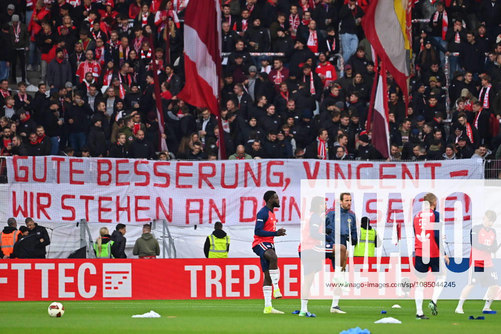 Transparent banner in the Bayern fan section with get-well wishes for the ailing coach Vincent KOMPANY of Bayern Munich; in the foreground: Harry KANE of Bayern Munich, Serge GNABRY of FC Bayern Munich, Konrad LAIMER of Bayern Munich, Dayot UPAMECANO, Bayern Munich; Lennart KARL, Bayern Munich, warming up. Soccer, Bundesliga, 2026–2027 season, Matchday 7, SC Freiburg vs. FC Bayern Munich on October 25, 2026, Europa-Park Stadium
