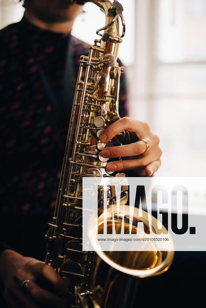 IMAGO Creative: Bildung, Musikerziehung Midsection of woman playing saxophone at studio , model released, property released