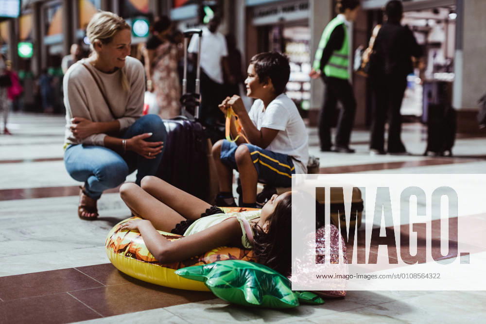 Mother talking to children while waiting at train station , model released, property released