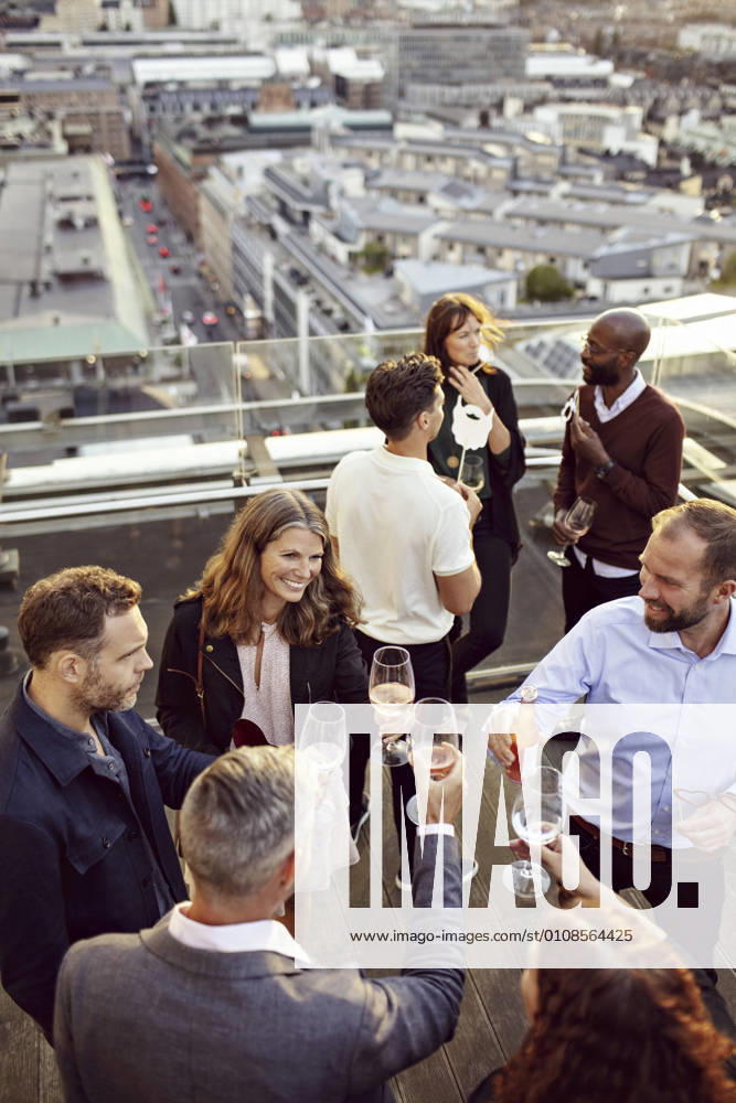 High angle view of coworkers toasting wineglasses while partying at building terrace , model released, property released