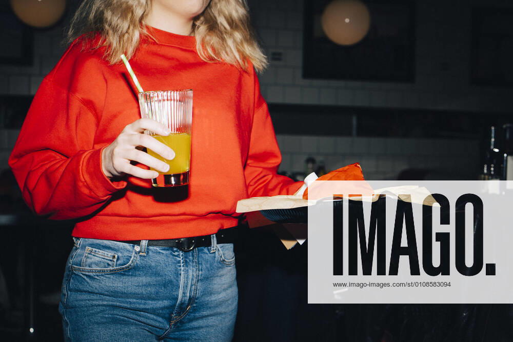 Midsection of female waitress with food and drink in restaurant Sweden, Stockholm, model released, property released