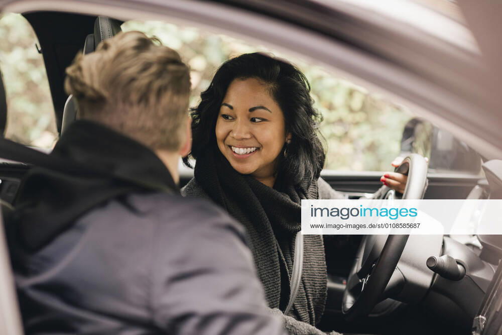 Smiling woman looking back while driving electric car Sweden, Stockholm, model released