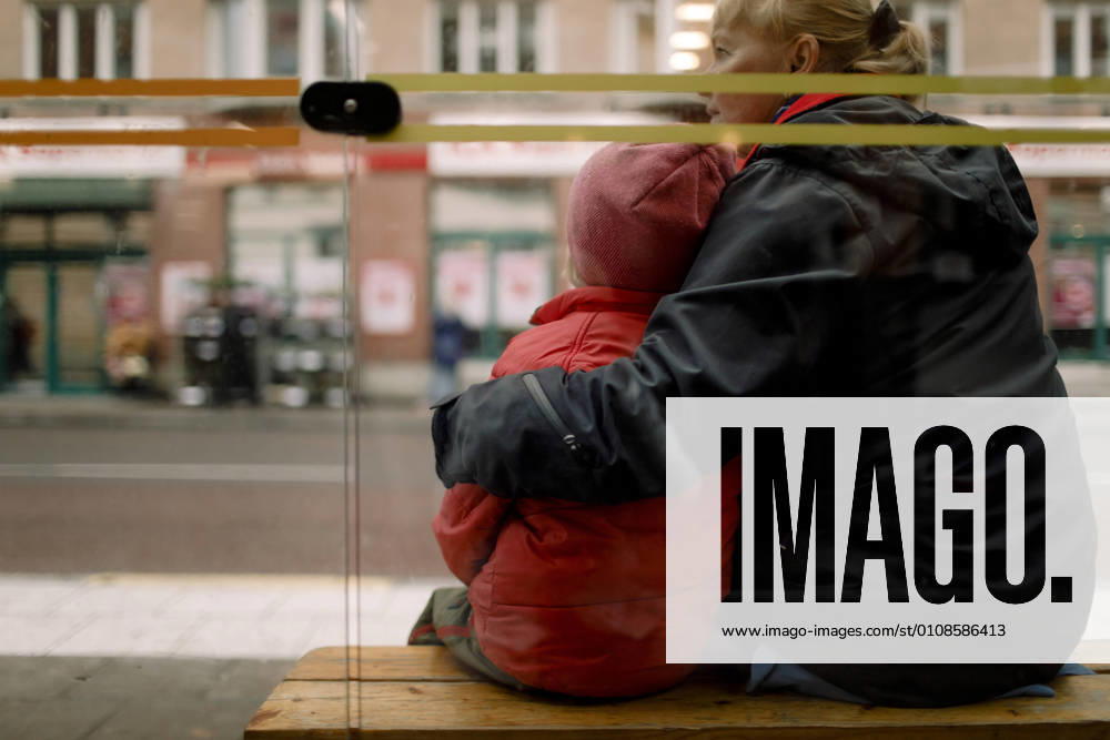 Rear view of grandmother with grandson sitting on bench in city Sweden, Stockholm, model released