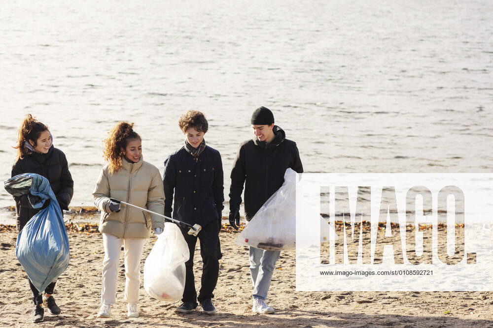 IMAGO Creative: Klimawandel - Umwelterziehung Male and female environmentalists with microplastics garbage walking against lake Sweden, Stockholm, model released