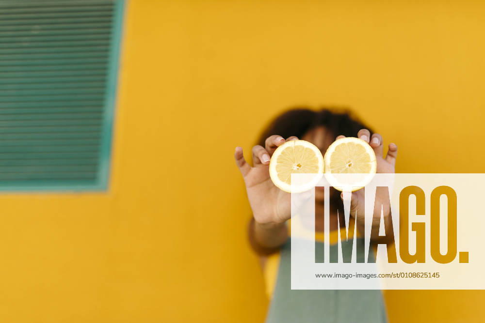 Close-up of young woman holding halved lemons model released Symbolfoto TCEF00481