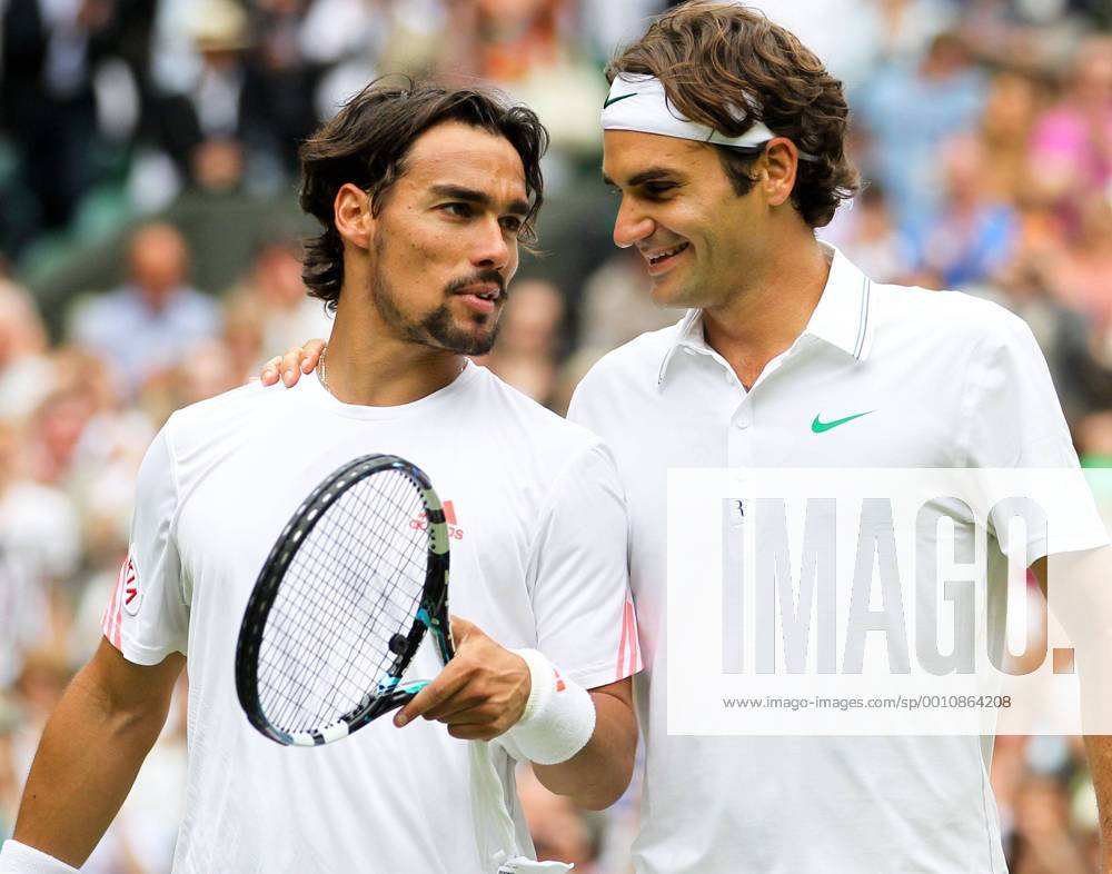 Switzerland s Roger Federer (R) talks with Italy s Fabio Fognini after the men s singles second round match at the 2012 Wimbledon Championships tennis tournament in Wimbledon