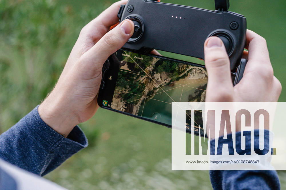 IMAGO Creative: Klimawandel - Zukunft und Innovation Unrecognizable male with remote controller operating unmanned drone and recording video of spectacular landscape
