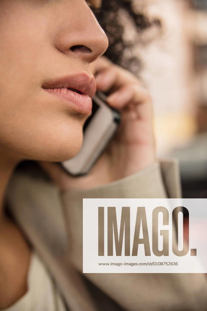 Crop shot in close-up of female lips while using smartphone and speaking on phone., Model released