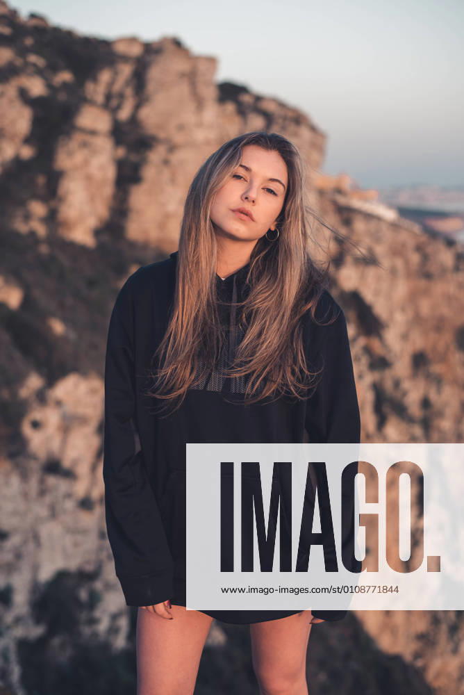 IMAGO Creative: Sommer, Abendspaziergang Young lady standing on stones looking at camera, Model released
