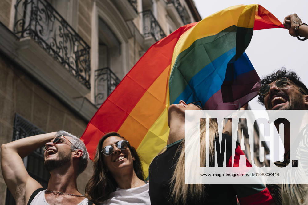 Group of friends with a flag of gay pride in the city of Madrid