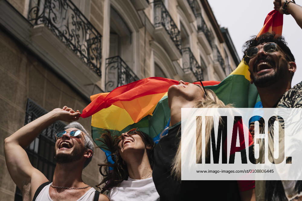 Group of friends with a flag of gay pride in the city of Madrid