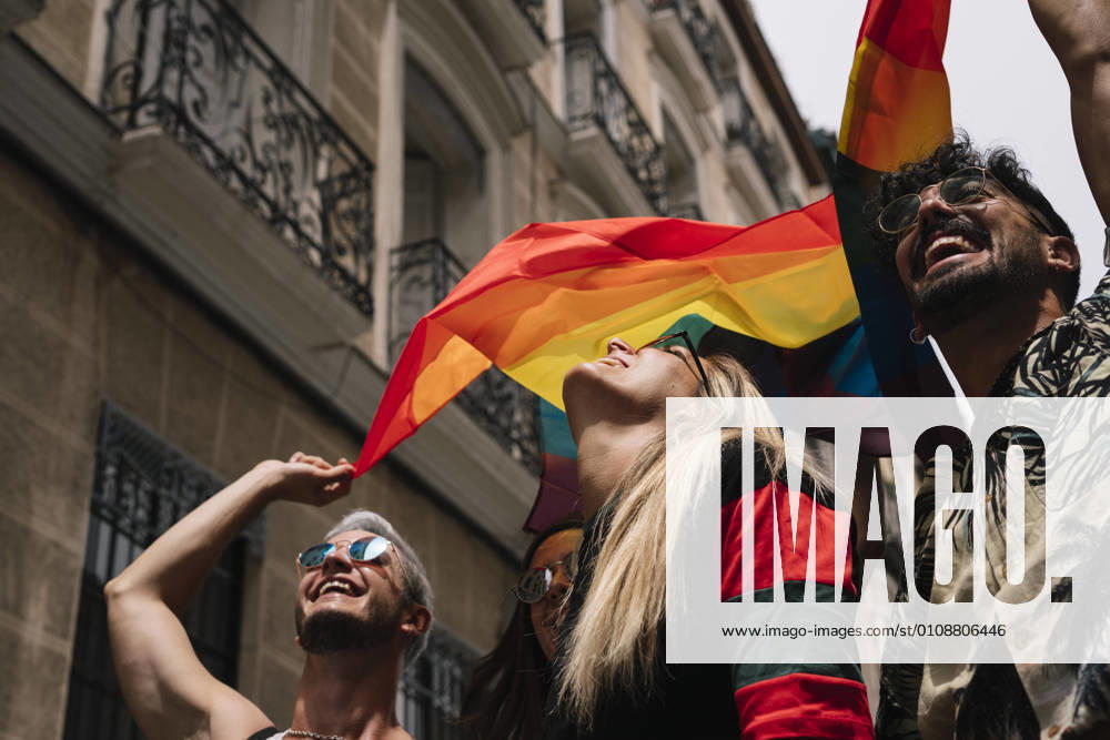 Group of friends with a flag of gay pride in the city of Madrid