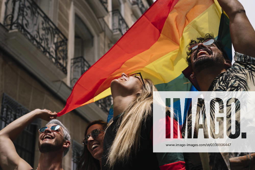 Group of friends with a flag of gay pride in the city of Madrid
