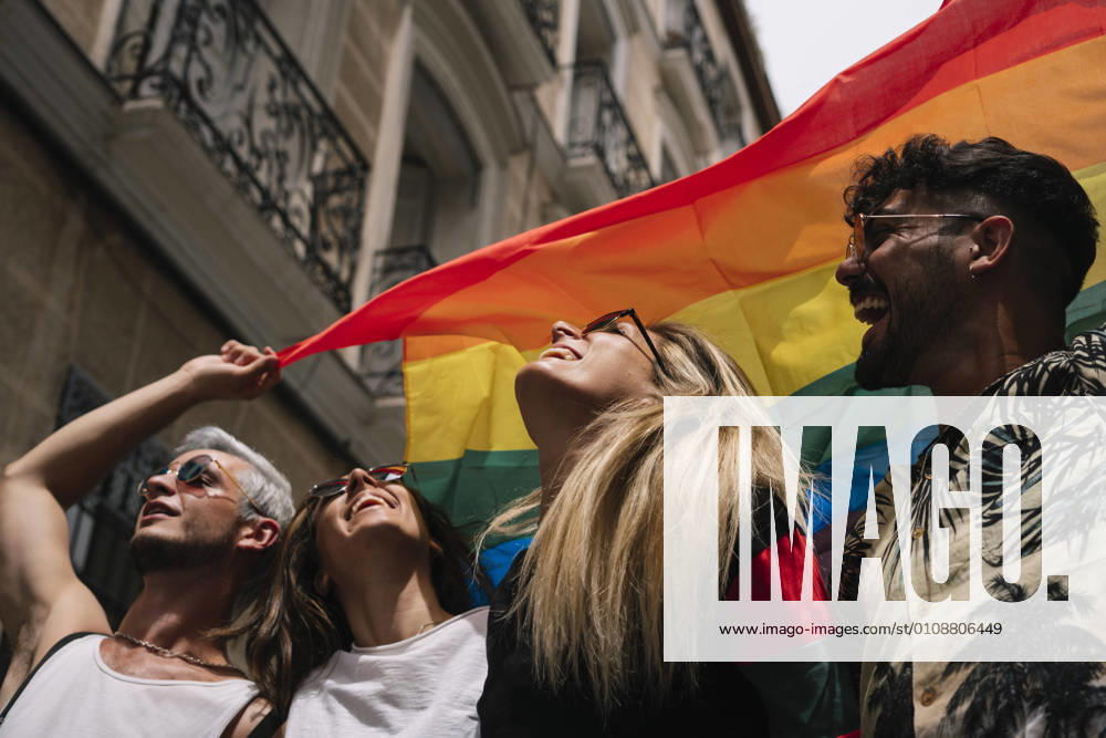 Group of friends with a flag of gay pride in the city of Madrid
