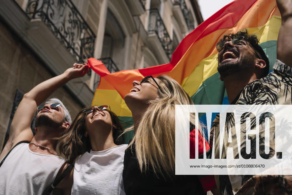Group of friends with a flag of gay pride in the city of Madrid