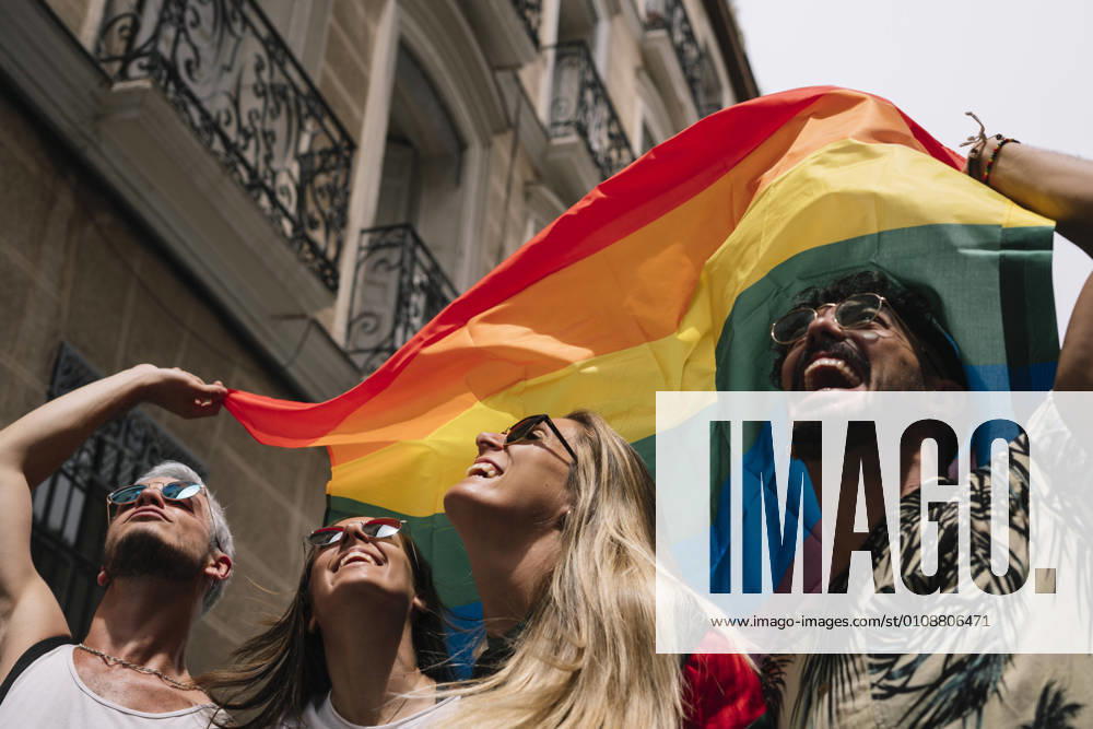 Group of friends with a flag of gay pride in the city of Madrid
