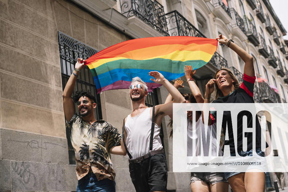Group of friends with a flag of gay pride in the city of Madrid