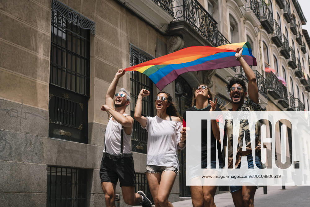 Group of friends with a flag of gay pride in the city of Madrid
