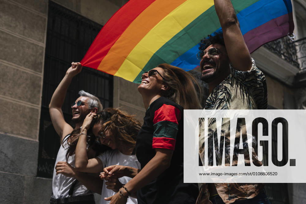 Group of friends with a flag of gay pride in the city of Madrid