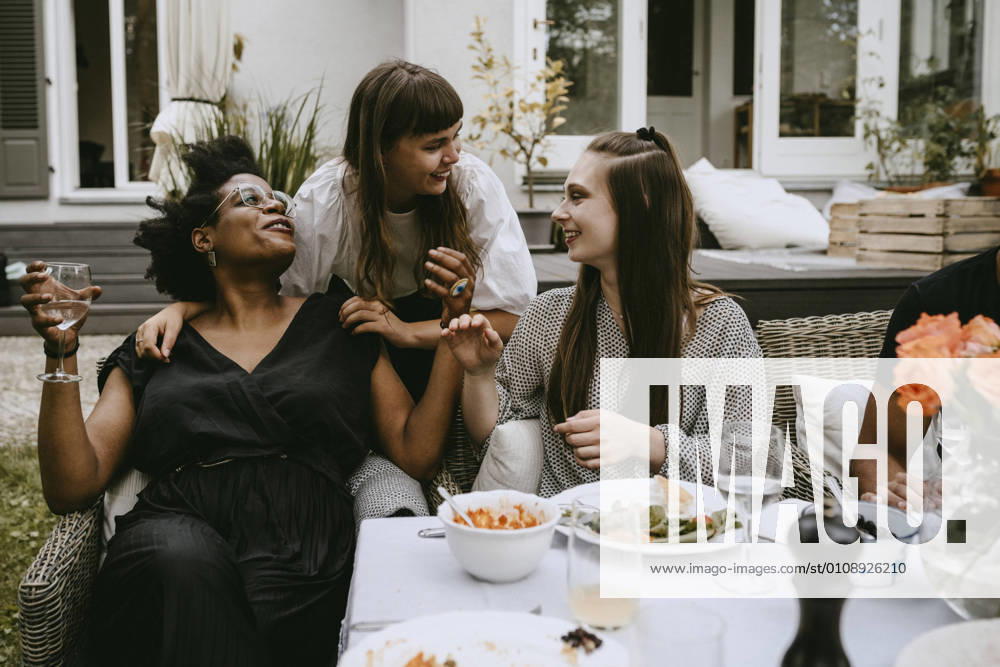 Smiling female friends talking while enjoying during social gathering Sweden, Stockholm, model released, property released