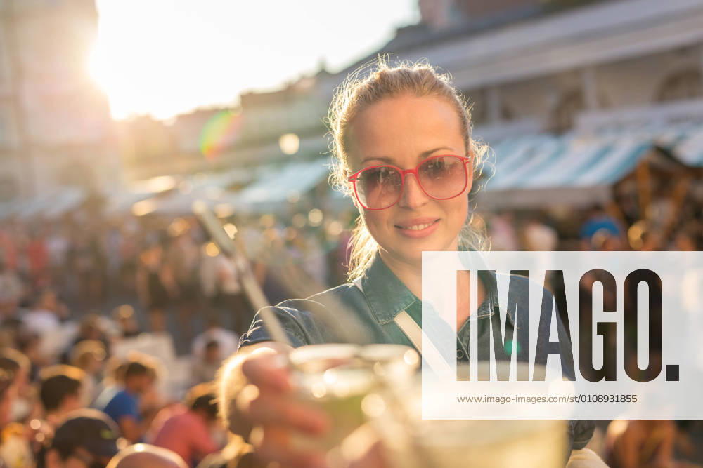 Beautiful young girl toasting on outdoor urban event. Beautiful young girl toasting outdoors on Open kitchen street food festival in Ljubljana, Slovenia. Popular summer urban tourist event in capital., model releasedwoman, toast, drink, festival, event, people, young, music, alcohol, fun, happiness, outdoors, youth, celebration, cheers, group, sunny, together, party, concert, lady, girl, vacations, cheerful, friends, friendship, smiling, summer, culture, food, leisure, adult, outdoor, lifestyle, happy, raised, bonding, cocktail, mohito, beautiful, urban, city, Open kitchen, Odprta kuhna, Ljubljana, Slovenia, square, crowd, tourism, tourist,