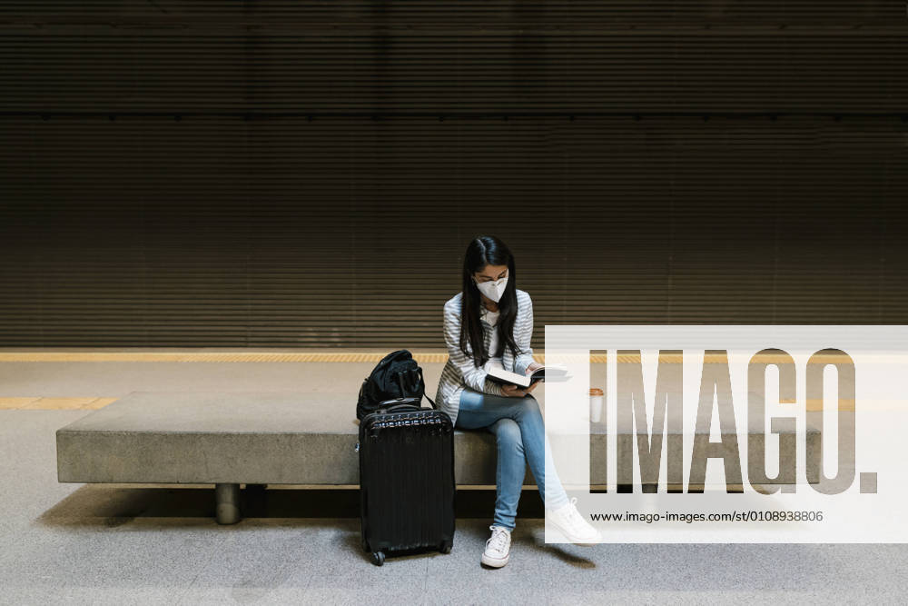 Female passenger reading book while sitting at metro station model released Symbolfoto EGAF01000