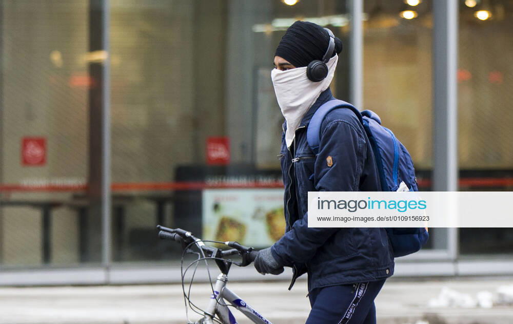 (201228) -- TORONTO, Dec. 28, 2020 -- A man wearing a face covering walks a bicycle on the street in Toronto, Ontario, Canada, Dec. 27, 2020. Canada s COVID-19 cases surpassed 550,000, with the total hitting 552,020, including 14,963 deaths, as of Sunday afternoon, according to CTV. Ontario, the most populous province in Canada, reported 2,005 new cases, bringing its total case count to 171,416 on Sunday. (Photo by Xinhua) CANADA-ONTARIO-COVID-19 ZouxZheng