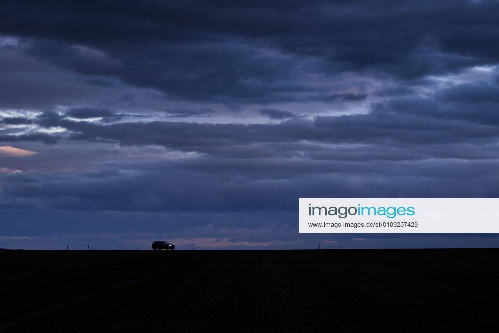 A car stands out in blue hour on a country road in Vierkirchen, 29 12 2020 Vierkirchen Germany