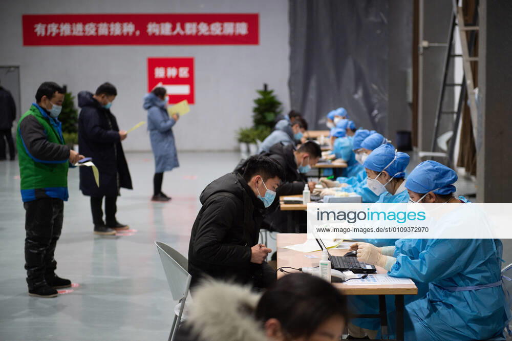 (210103) -- BEIJING, Jan. 3, 2021 -- People fill the informed consent form out before the COVID-19 vaccination at a temporary vaccination site in Beijing, capital of China, Jan. 2, 2021. Beijing started administering COVID-19 vaccines among specific groups of people with higher infection risks. Nine groups of people aged 18 to 59 will receive the vaccine before the Spring Festival of 2021, which falls on Feb. 12. These include frontline customs inspectors of imported cold-chain goods and personnel working in the overseas and domestic transportation sector. ) XINHUA PHOTOS OF THE DAY ChenxZhonghao
