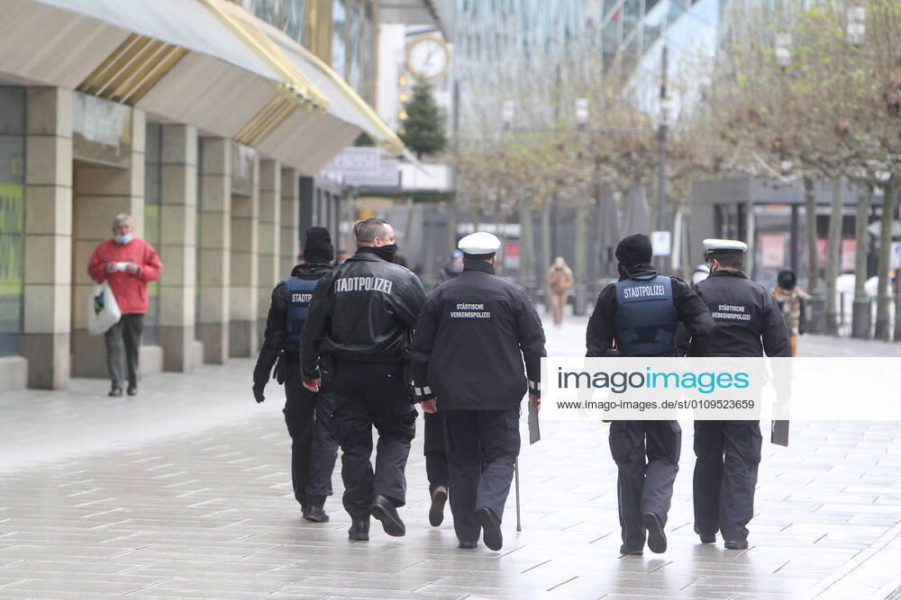On the occasion of the Corona crisis, a police patrol of the Hesse State Police controls the observance of the contact prohibitions as well as minimum distances during the lockdown in the largely deserted pedestrian zone and shopping street Zeil in the city centre of Frankfurt, Hesse, Germany.