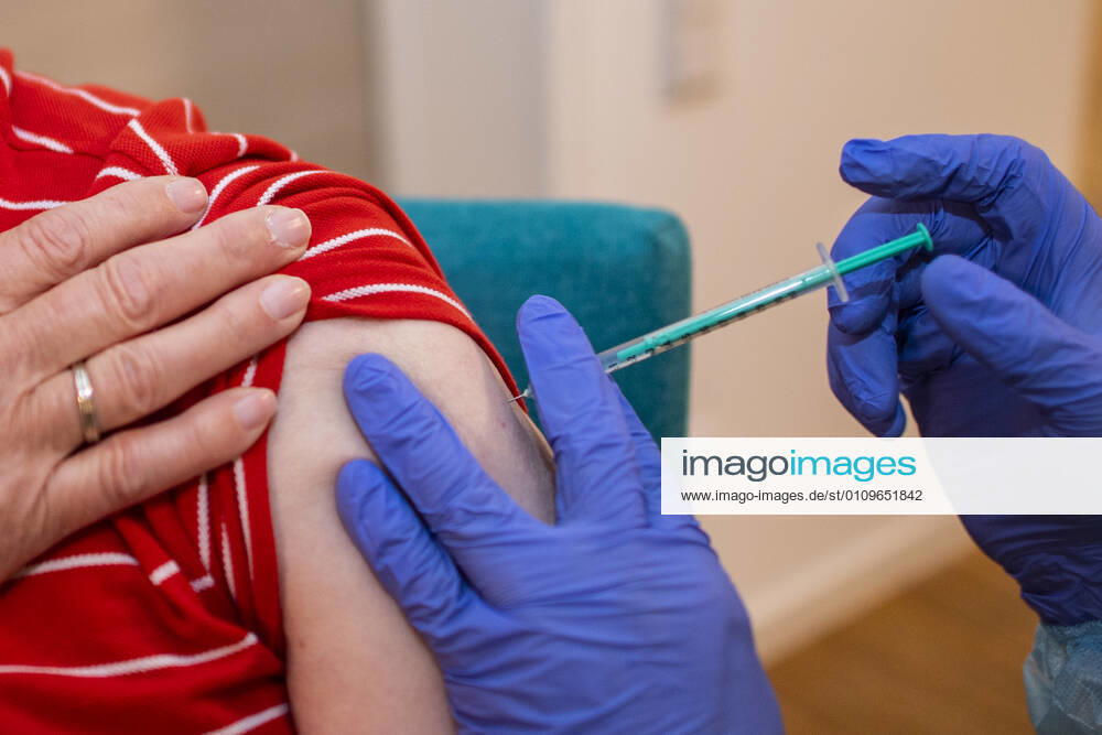 Corona vaccination in a home for the elderly A doctor places a needle on the upper arm of a resident of a home for the elderly who is being vaccinated against an infection with the corona virus In a home for the elderly, the residents are vaccinated against an infection with the corona virus Two vaccinations wit