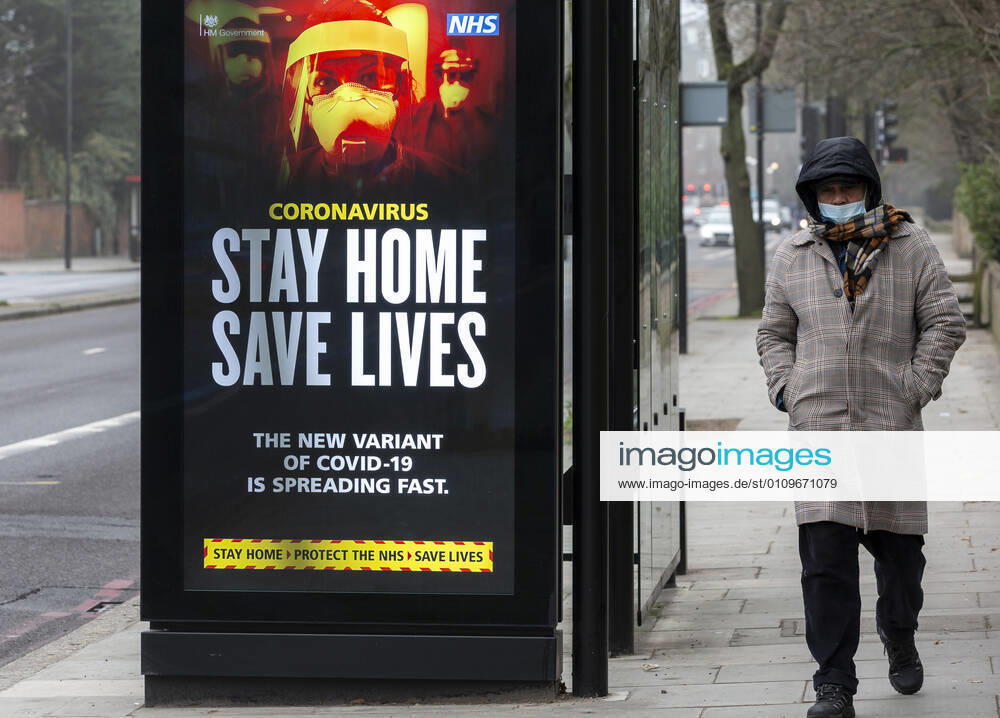 (210110) -- LONDON, Jan. 10, 2021 -- A man wearing a face mask walks past an advertising board reading Stay Home Save Lives in London, Britain, Jan. 10, 2020. The coronavirus-related deaths in Britain surpassed 80,000 on Saturday with another 1,035 reported in the country. ) BRITAIN-LONDON-COVID-19-CASES HanxYan