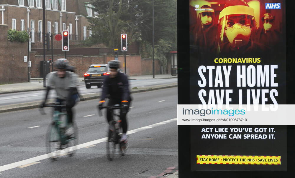 (210110) -- LONDON, Jan. 10, 2021 -- People cycle past an advertising board reading Stay Home Save Lives in London, Britain, Jan. 10, 2021. The coronavirus-related deaths in Britain surpassed 80,000 on Saturday with another 1,035 reported in the country. ) BRITAIN-LONDON-COVID-19-CASES HanxYan