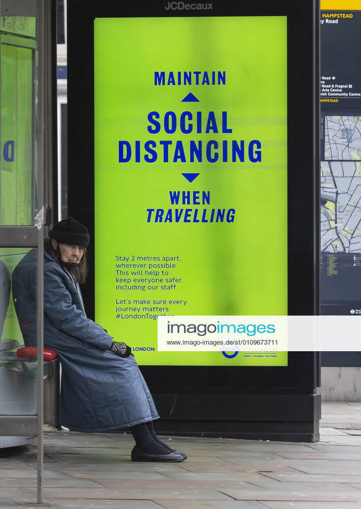 (210110) -- LONDON, Jan. 10, 2021 -- A person wearing a face mask sits next to an advertising board reading Maintain social distancing when travelling at a bus stop in London, Britain, Jan. 10, 2021. The coronavirus-related deaths in Britain surpassed 80,000 on Saturday with another 1,035 reported in the country. ) BRITAIN-LONDON-COVID-19-CASES HanxYan