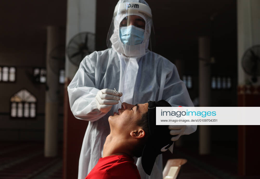 (210111) -- RAFAH, Jan. 11, 2021 -- A medical worker collects a swab sample from a young man to test for the COVID-19 in the southern Gaza Strip city of Rafah, Jan. 11, 2021. (Photo by Xinhua) MIDEAST-GAZA-RAFAH-COVID-19-TEST KhaledxOmar