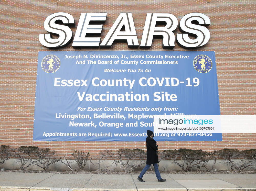 An Essex County COVID-19 Vaccination Site sign hangs below a sign for Sears at a closed Sears retail store location at the Livingston Mall in Livingston, New Jersey on Monday, January 11, 2021. Public health agencies and health-care groups are using the retailer s empty stores to deliver Vaccines in several locations around parts of the United States. NYP20210111101 JohnxAngelillo