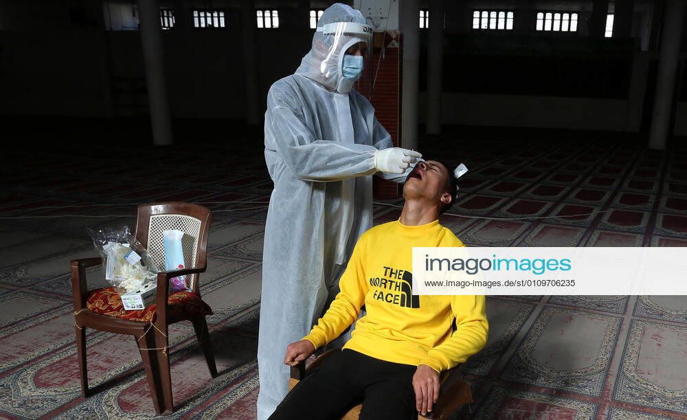 Deir Al-Balah, Gaza Strip, Palestinian Territory: A Palestinian medical worker wearing protective gear, takes a random swab sample for COVID-19 testing inside a mosque, in Deir al-Balah, central of Gaza Strip, on January 11, 2021. The Palestinian Authority (PA) has said it expects to receive its first COVID-19 vaccine doses in March under a deal with British drug giant AstraZeneca, and accused Israel of ignoring its responsibilities to ensure vaccines are available in occupied territory Deir Al-Balah Palestinian Territory - ZUMAap3_ 20210111_zaf_ap3_031