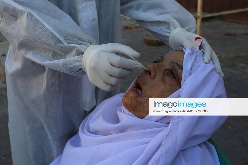 Deir Al-Balah, Gaza Strip, Palestinian Territory: A Palestinian medical worker wearing protective gear, takes a random swab sample for COVID-19 testing, in Deir al-Balah, central of Gaza Strip, on January 11, 2021. The Palestinian Authority (PA) has said it expects to receive its first COVID-19 vaccine doses in March under a deal with British drug giant AstraZeneca, and accused Israel of ignoring its responsibilities to ensure vaccines are available in occupied territory Deir Al-Balah Palestinian Territory - ZUMAap3_ 20210111_zaf_ap3_044