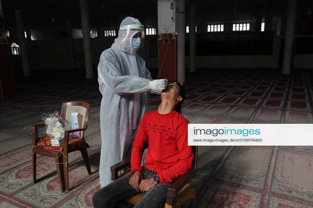 Deir Al-Balah, Gaza Strip, Palestinian Territory: A Palestinian medical worker wearing protective gear, takes a random swab sample for COVID-19 testing inside a mosque, in Deir al-Balah, central of Gaza Strip, on January 11, 2021. The Palestinian Authority (PA) has said it expects to receive its first COVID-19 vaccine doses in March under a deal with British drug giant AstraZeneca, and accused Israel of ignoring its responsibilities to ensure vaccines are available in occupied territory Deir Al-Balah Palestinian Territory - ZUMAap3_ 20210111_zaf_ap3_064