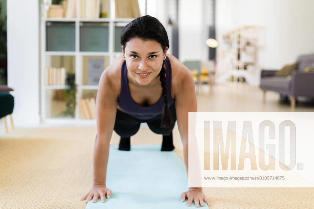 IMAGO Creative: 2021 Trends Young woman doing push ups at home model released Symbolfoto property released GIOF09151