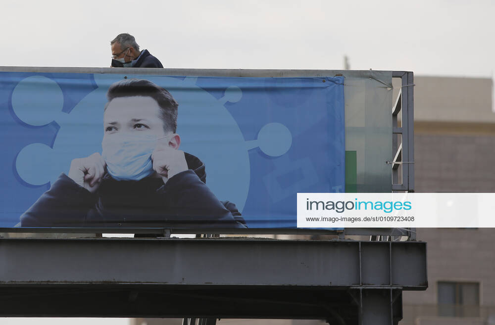 (210111) -- BEIRUT, Jan. 11, 2021 -- A man is seen behind a poster encouraging mask wearing in Beirut, Lebanon, on Jan. 11, 2021. Lebanon s Higher Defense Council declared on Monday a state of emergency between Jan. 14-25 that includes a total lockdown in hope to restrict further spread of COVID-19, Al-Jadeed local TV channel reported. ) LEBANON-BEIRUT-COVID-19-STATE OF EMERGENCY BilalxJawich