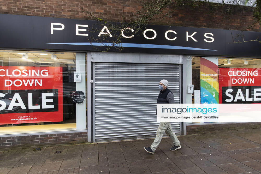 A man wearing a face mask walks past Peacocks fashion shop. Newport United Kingdom - ZUMAs197 20210111_zab_s197_013