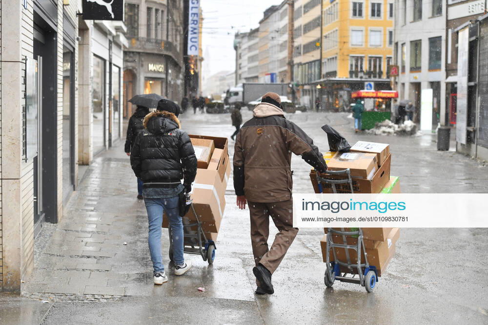 UPS parcel delivery driver at work,parcel carrier,United Parcel in downtown in munich delivery in downtown,pedestrian zone in munich on 12 01 2021 service,parcel,parcel service,deliver,unload,send,transporter,hand truck