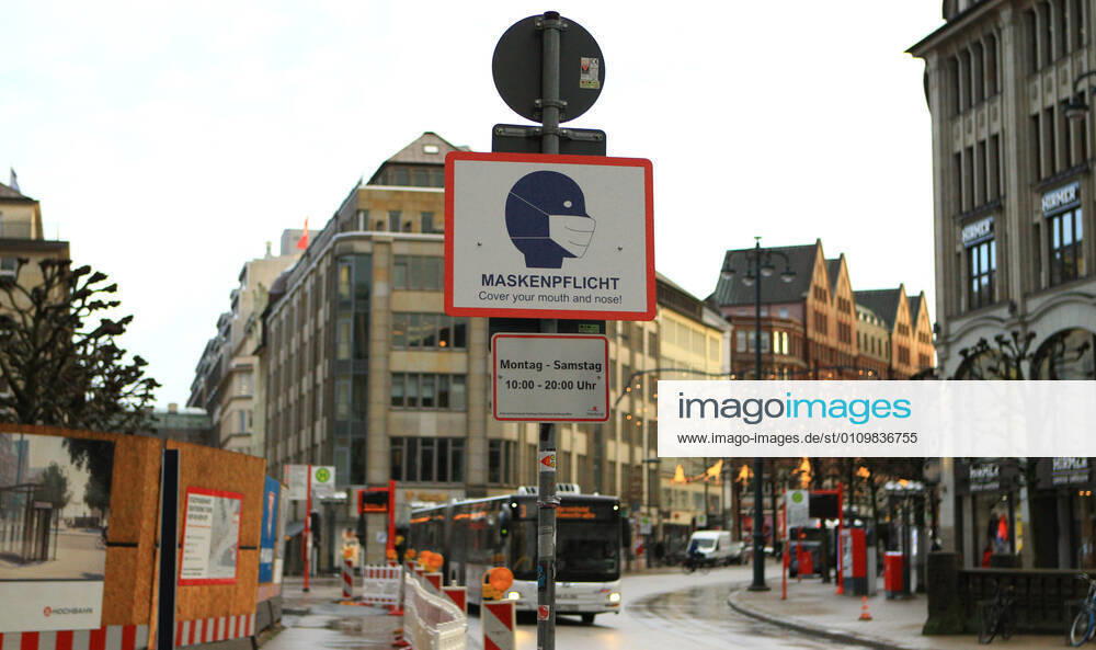 A sign attached to a lamppost indicates that masks are compulsory at certain times in Mönckebergstraße in Hamburg Altstadt Hamburg