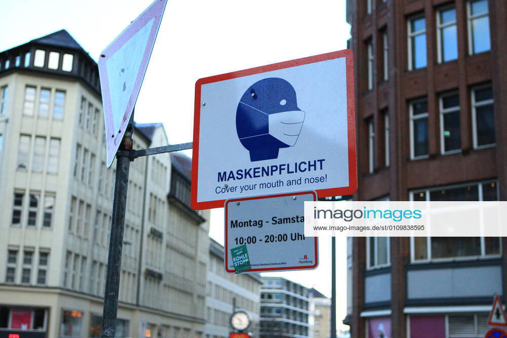 A sign attached to a lamppost indicates that masks are compulsory at certain times in Mönckebergstraße in Hamburg Altstadt Hamburg