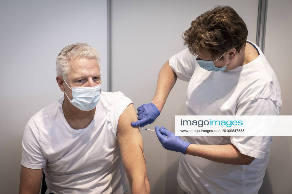 Soeren Bjoern Jensen receives the first bite in connection with the first vaccine center in the Capital Region opening in OEksnehallen, at Halmtorvet in Copenhagen, Wednesday 13 January 2021, Copenhagen Denmark
