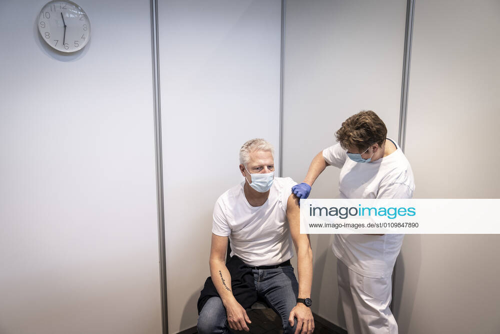 Soeren Bjoern Jensen receives the first bite in connection with the first vaccine center in the Capital Region opening in OEksnehallen, at Halmtorvet in Copenhagen, Wednesday 13 January 2021, Copenhagen Denmark