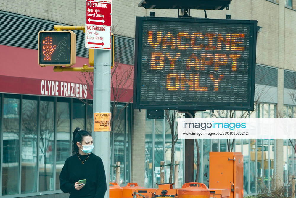 A woman walks past a sign as the New York State opens a mass vaccination site at the Jacob Javits Convention Center on Manhattan s West Side on January 13, 2021 in New York. New York USA - ZUMAb148 20210113_zap_b148_005